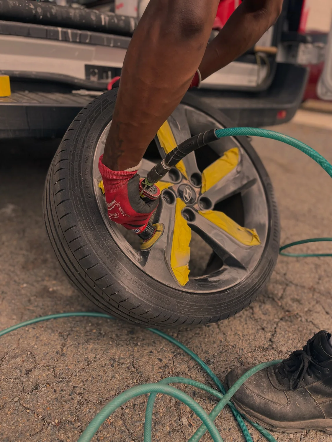 Technician preparing a masked wheel during a cosmetic repair